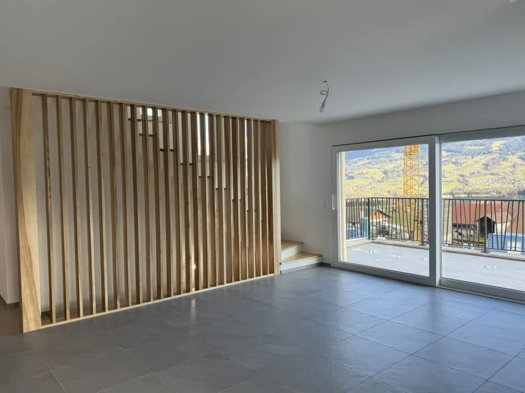 Séjour avec claustra en bois rénové par Home Création Architecture, entreprise de rénovation à Bulle